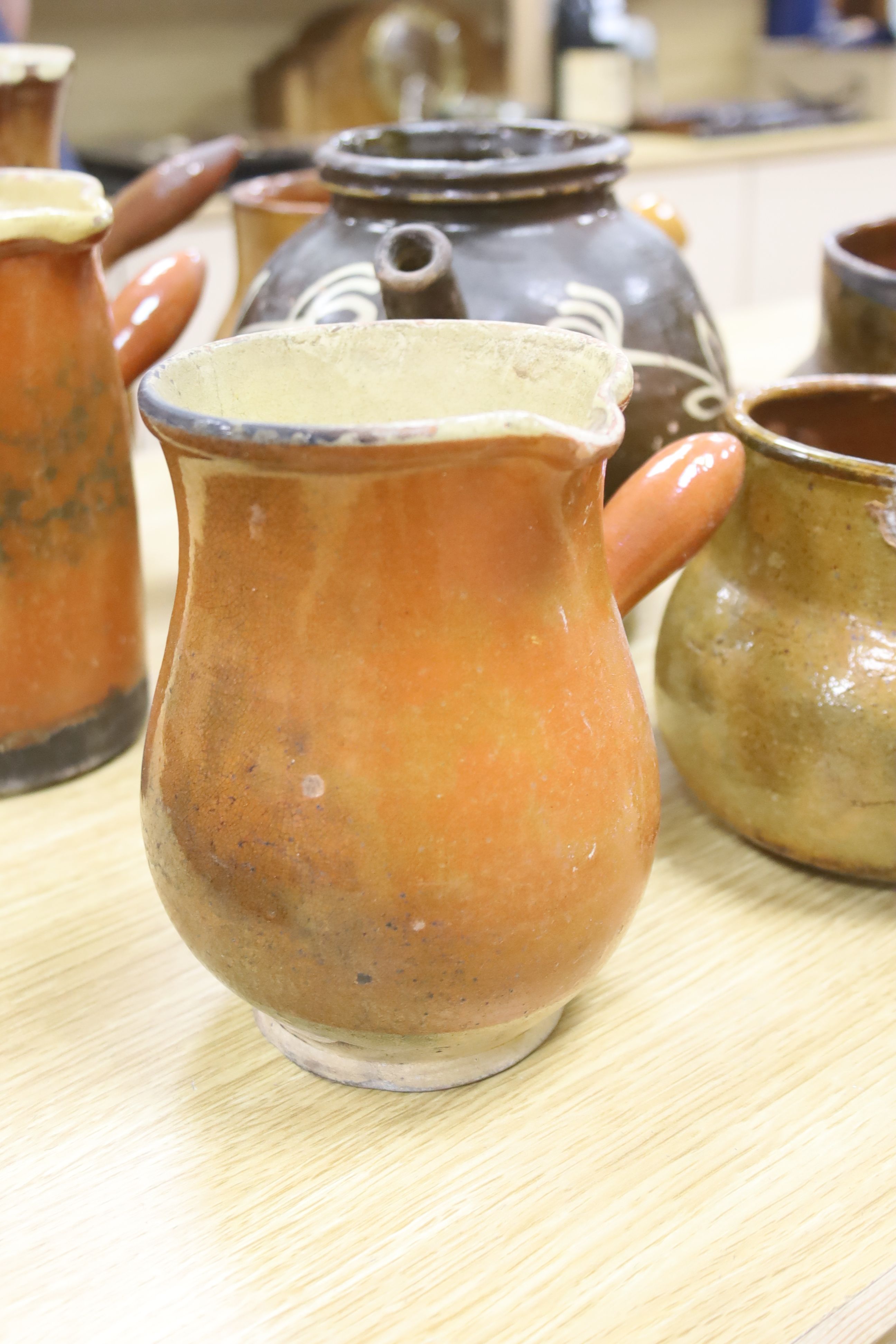 Six vintage Continental, probably French, glazed stoneware cooking pots and a slip-decorated stoneware confit pot